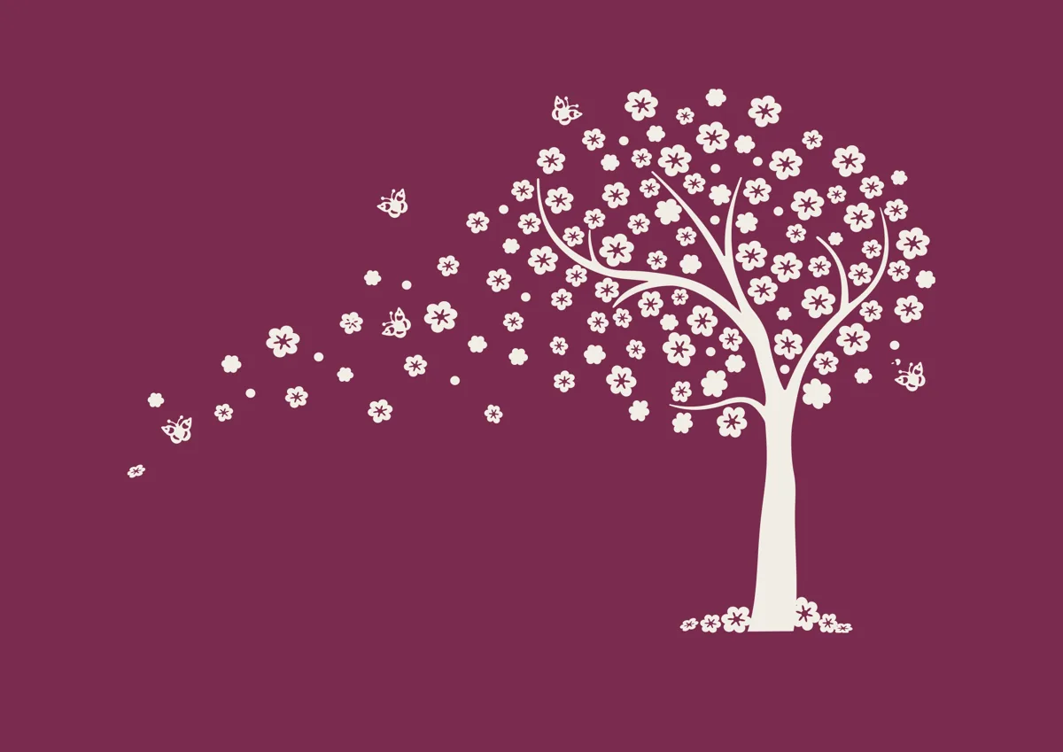 Tree with blossom petals blowing from its branches